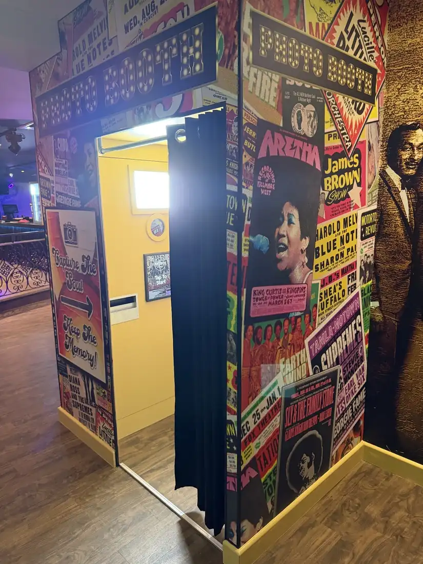 The Jukebox Lounge photobooth set into a wall of colourful retro music posters