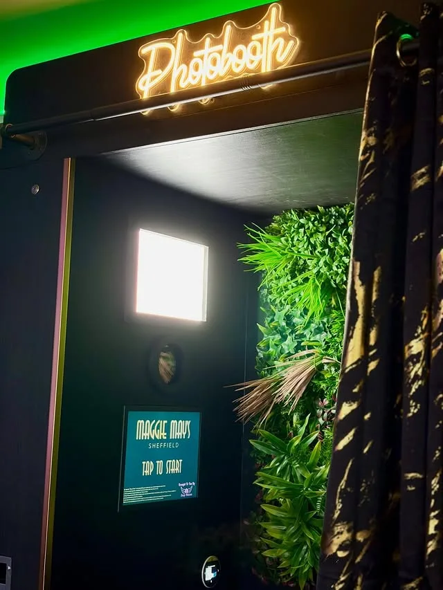 Bespoke Maggie May's photobooth with illuminated sign and plant wall