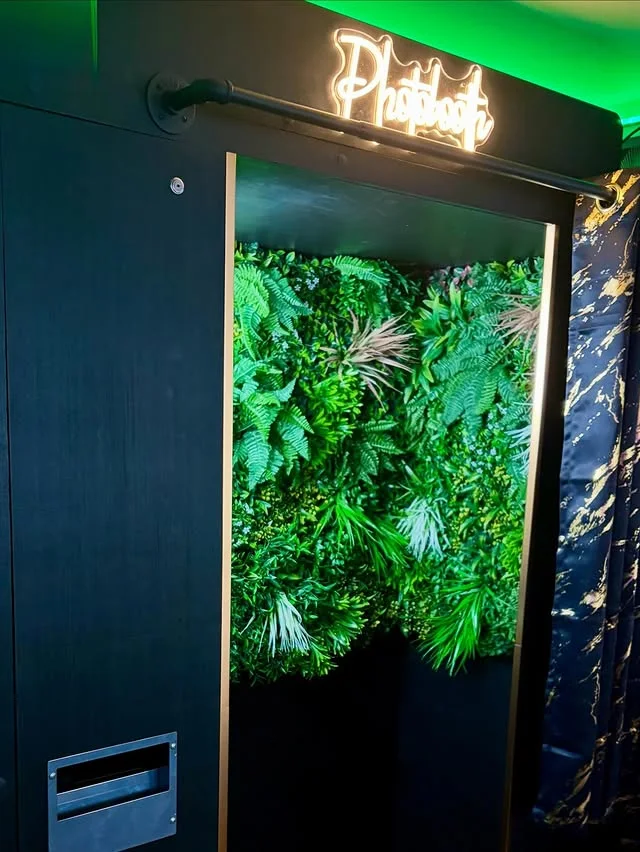 Maggie May's photobooth entrance framed by a bespoke plant wall